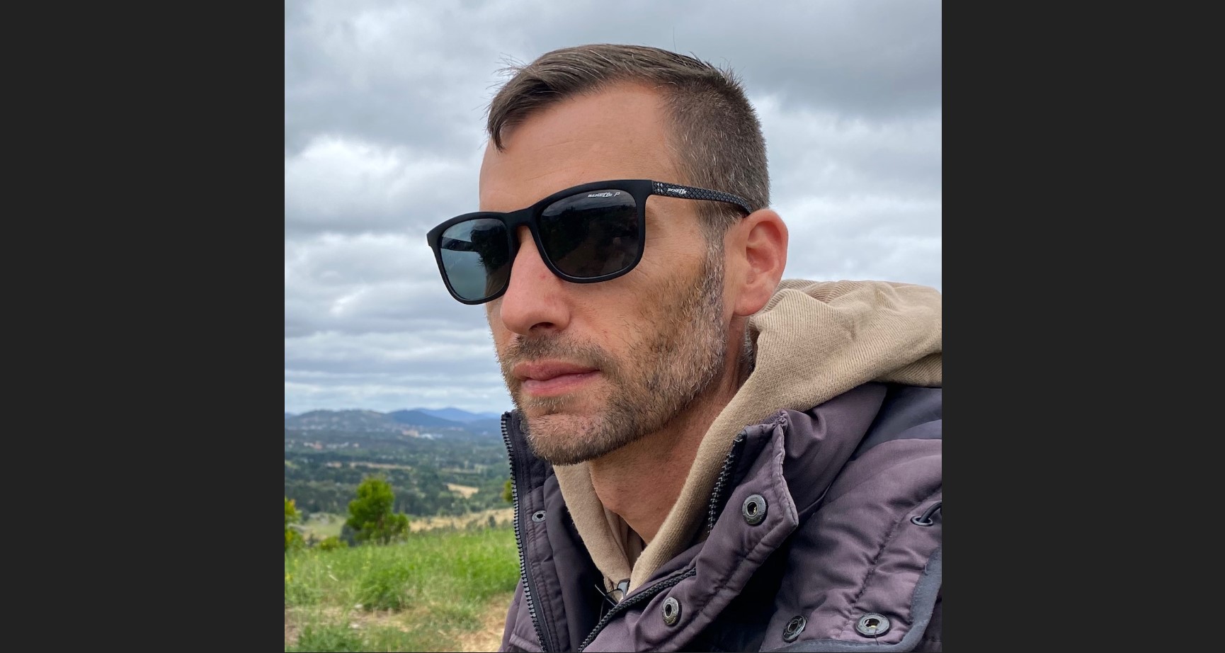 A man wearing sun glasses looking away from the camera