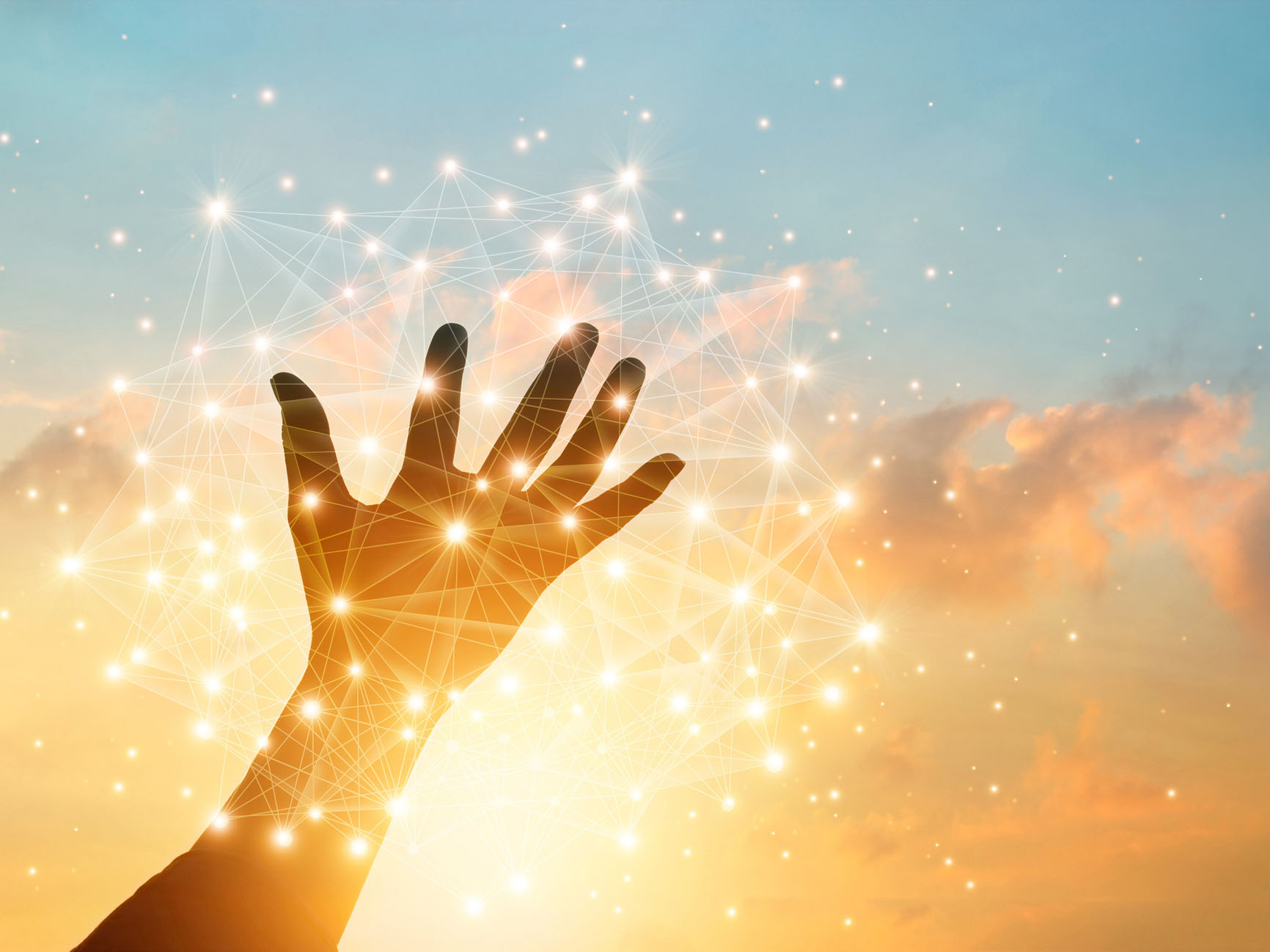 A human hand reaching towards a digital network overlay against a sky with clouds at sunset.