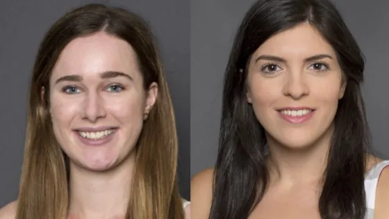 Portrait of two young women smiling at the camera, one with light brown hair and the other with dark brown hair, against a gray background.