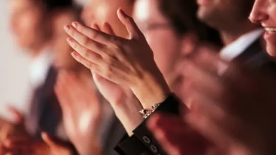 Several people clapping their hands enthusiastically.