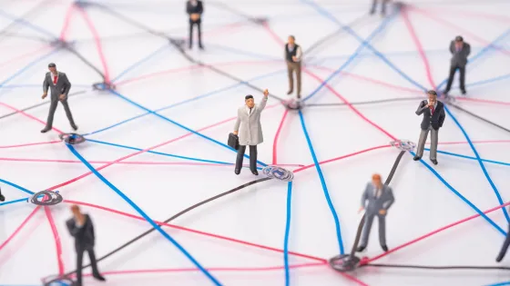 Image of social connectedness represented by miniture figures of people who are connected through networks represented by string
