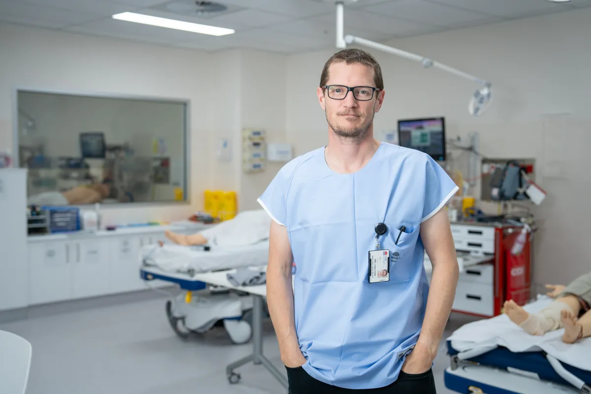 Dr Nathan Oates wearing scrubs in a hospital room