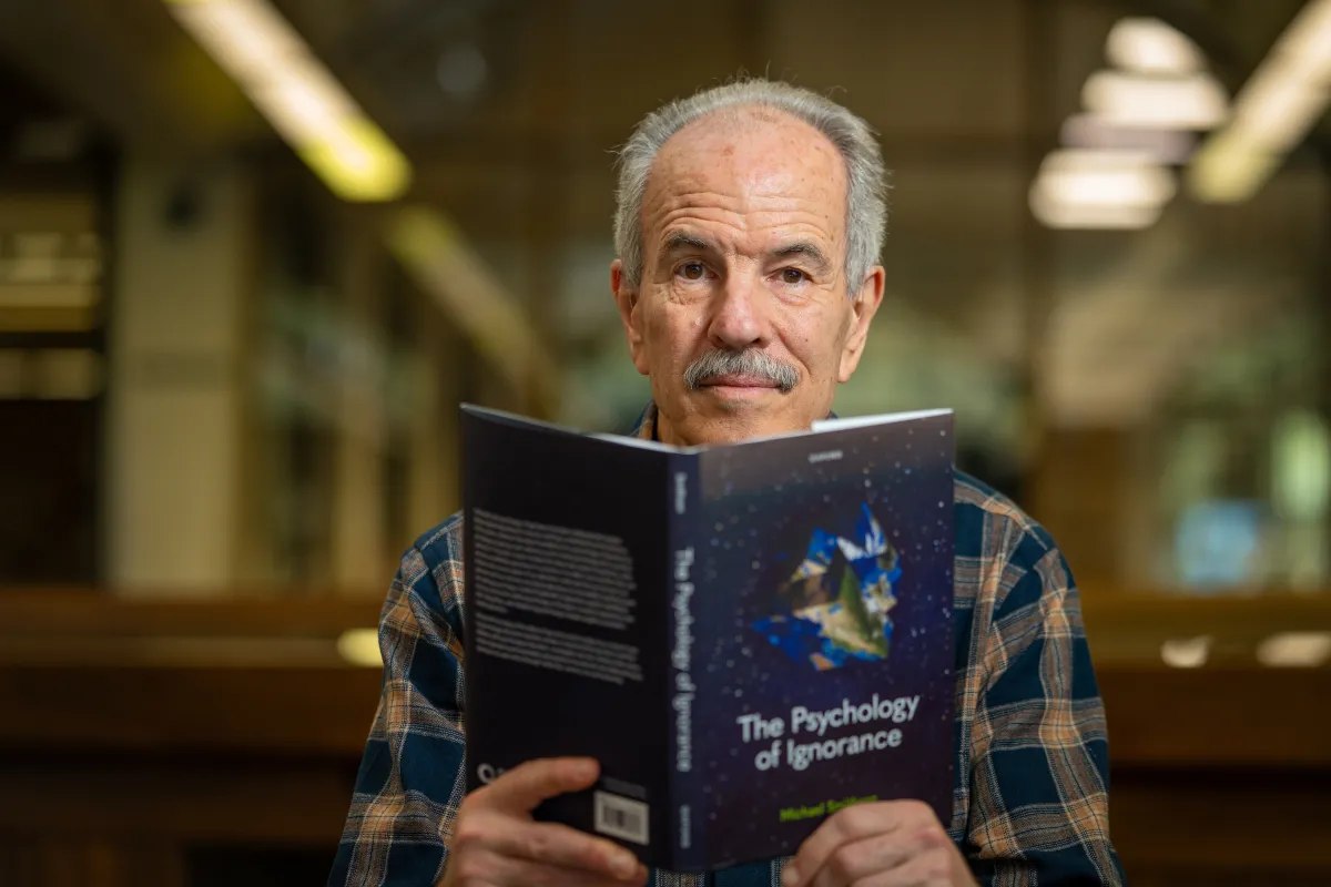 Professor Michael Smithson is reading a book titled The Psychology of Ignorance