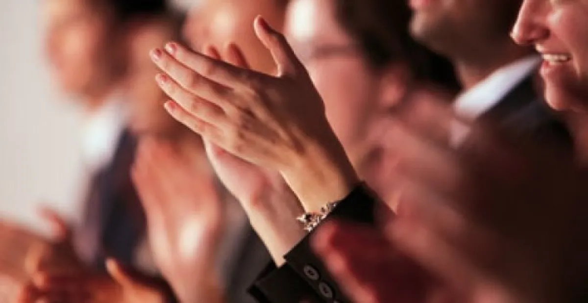 Several people clapping their hands enthusiastically.