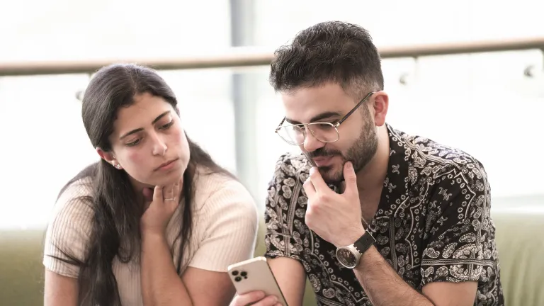 a couple look at a phone